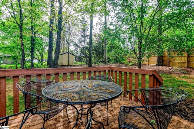 15 Red Cedar Ct, Simpsonville, SC 29681 - deck with a shed, outdoor dining area, fence, and an outbuilding