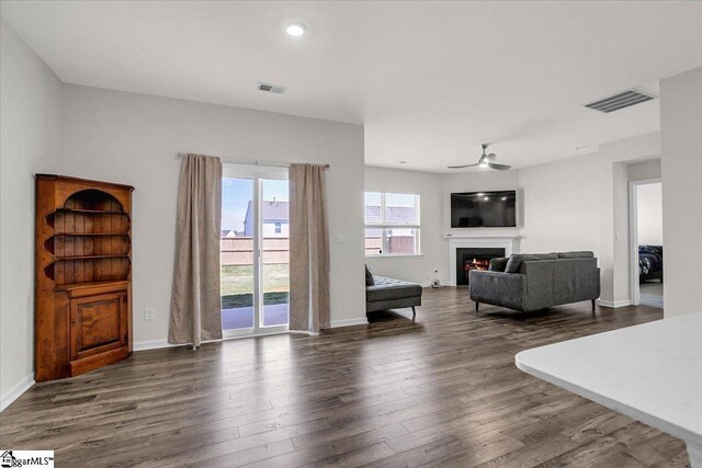 103 Slateford Cir, Piedmont, SC 29673 - living room with visible vents, dark wood-style flooring, a ceiling fan, and a warm lit fireplace