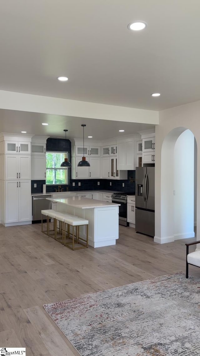 242 Queensbury Way, Spartanburg, SC 29302 - kitchen featuring arched walkways, white cabinetry, recessed lighting, a kitchen island, and stainless steel appliances