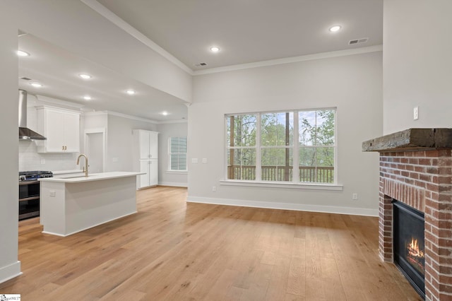 47 Park Vista Way, Greenville, SC 29617 - unfurnished living room with light wood-style floors, visible vents, ornamental molding, and a brick fireplace