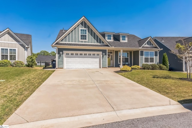 craftsman-style house with board and batten siding, driveway, and a front lawn