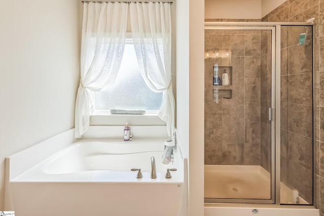 bathroom with a shower stall and a bath