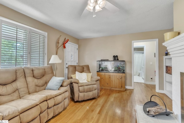 4150 Sandy Flat Rd, Taylors, SC 29687 - living area with a brick fireplace, light wood-type flooring, baseboards, and ceiling fan