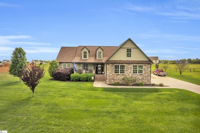 view of front of house featuring driveway, stone siding, and a porch