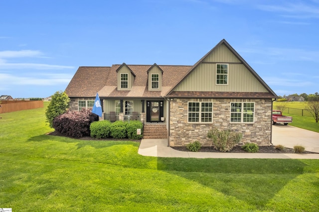 view of front of house featuring stone siding, covered porch, board and batten siding, and a shingled roof