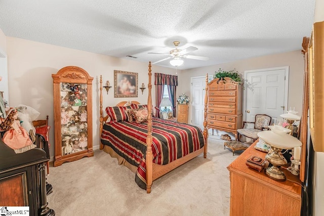 bedroom featuring visible vents, baseboards, a ceiling fan, a textured ceiling, and light colored carpet