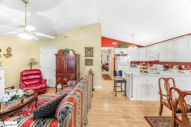 living room with visible vents, light wood finished floors, a ceiling fan, and lofted ceiling