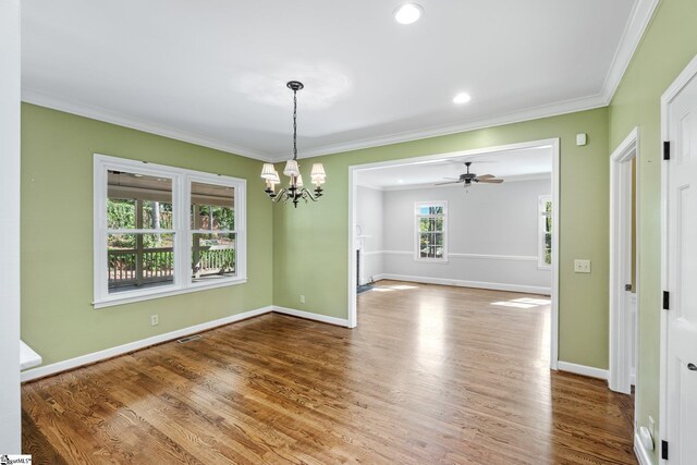 unfurnished room featuring visible vents, baseboards, crown molding, and wood finished floors