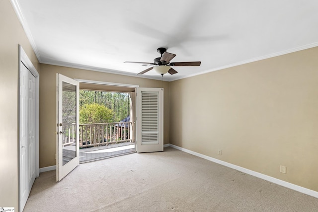 carpeted spare room featuring ceiling fan, baseboards, and ornamental molding