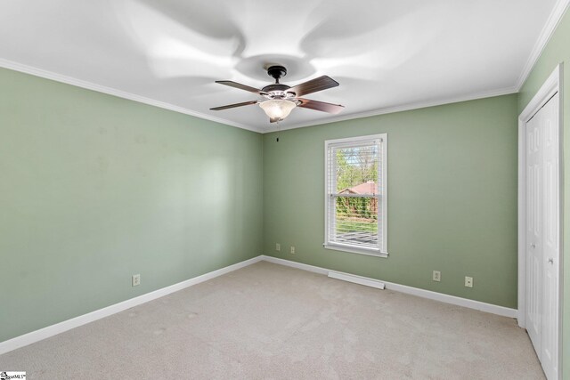 unfurnished bedroom featuring crown molding, a closet, and light carpet