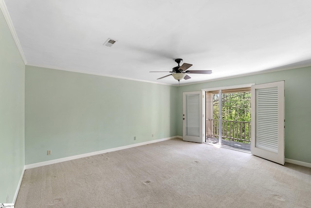 carpeted spare room featuring ceiling fan, baseboards, ornamental molding, and visible vents