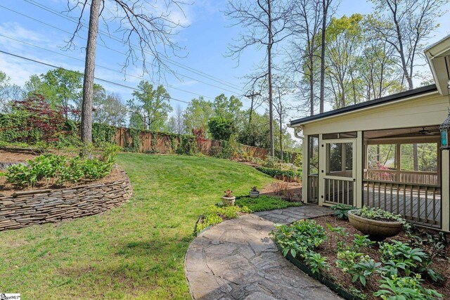 view of yard featuring fence and a sunroom