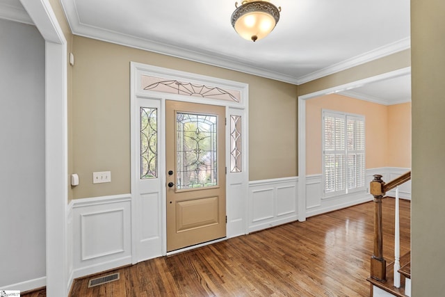entrance foyer featuring a wainscoted wall, visible vents, a wealth of natural light, and wood finished floors
