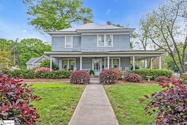 406 N Main St, Fountain Inn, SC 29644 - farmhouse inspired home featuring a chimney, a front yard, a standing seam roof, metal roof, and covered porch