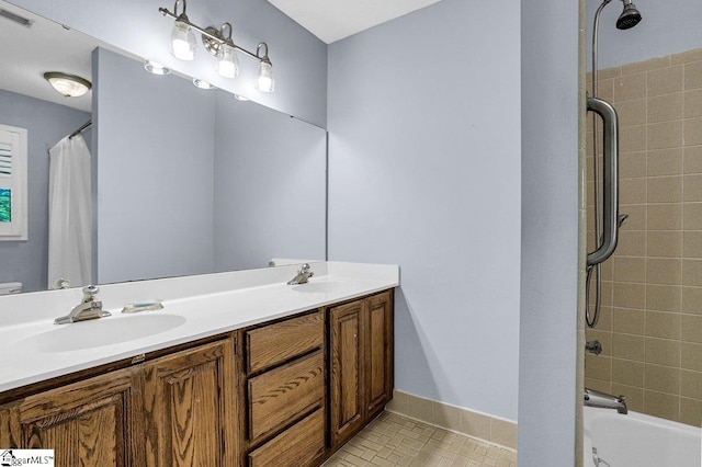 bathroom featuring double vanity, visible vents, baseboards, and a sink