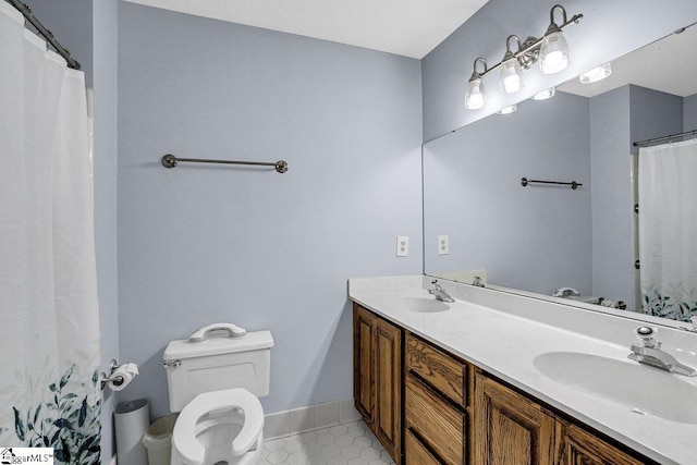 bathroom featuring a sink, toilet, double vanity, and tile patterned flooring