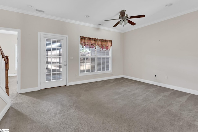 carpeted spare room featuring visible vents, baseboards, crown molding, and a ceiling fan