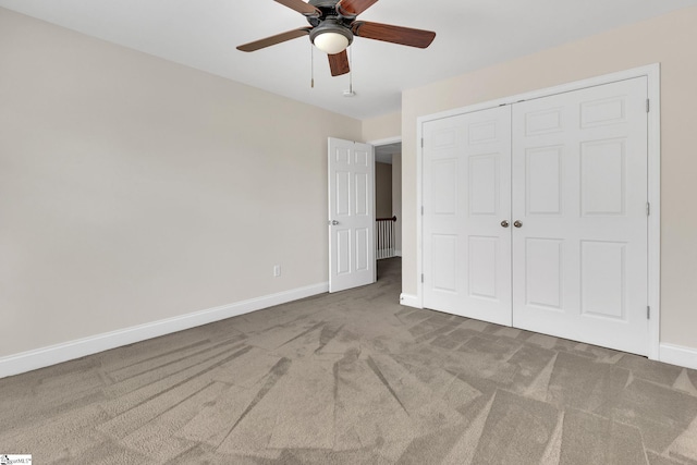 unfurnished bedroom with a closet, baseboards, a ceiling fan, and carpet floors