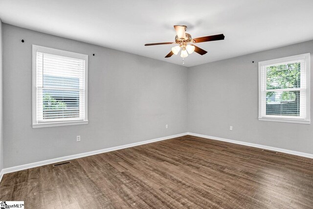 spare room featuring visible vents, baseboards, wood finished floors, and ceiling fan