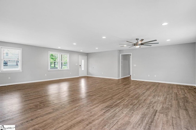unfurnished living room with recessed lighting, baseboards, and wood finished floors