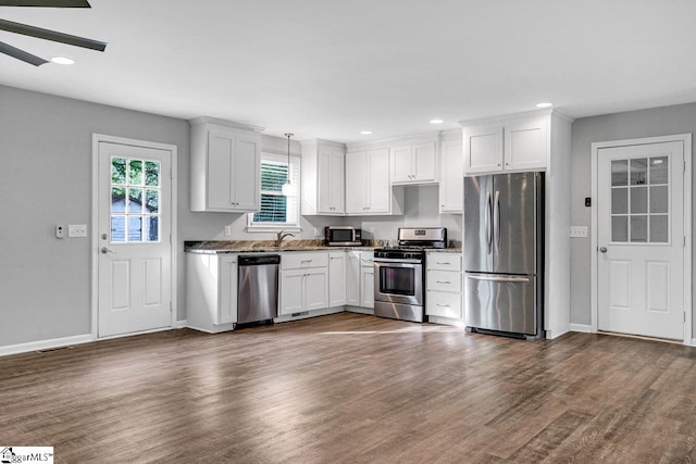 kitchen with dark wood-type flooring, white cabinets, recessed lighting, stainless steel appliances, and baseboards