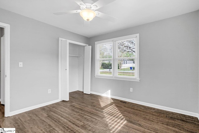 unfurnished bedroom with a closet, wood finished floors, baseboards, and a ceiling fan