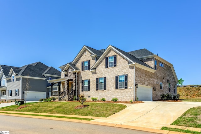 craftsman-style house with a garage, a front yard, concrete driveway, and brick siding