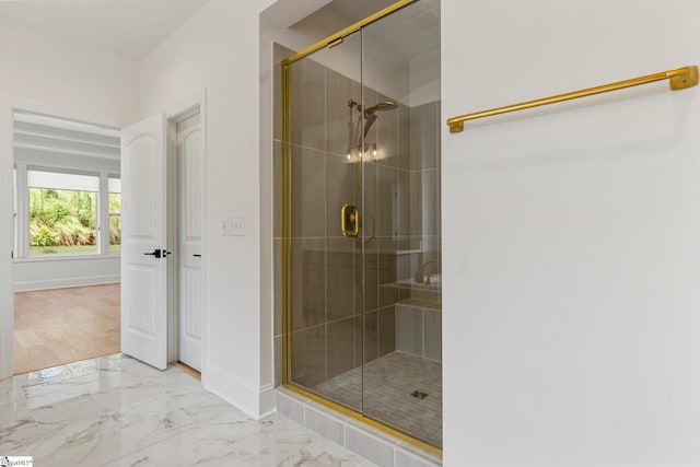 bathroom featuring a stall shower, marble finish floor, and baseboards