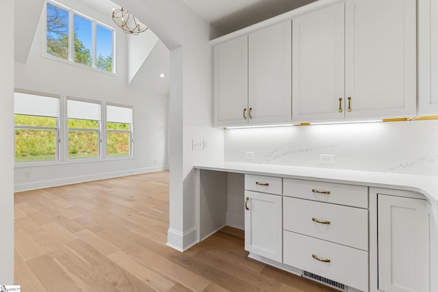 kitchen featuring visible vents, baseboards, plenty of natural light, light countertops, and light wood-style flooring