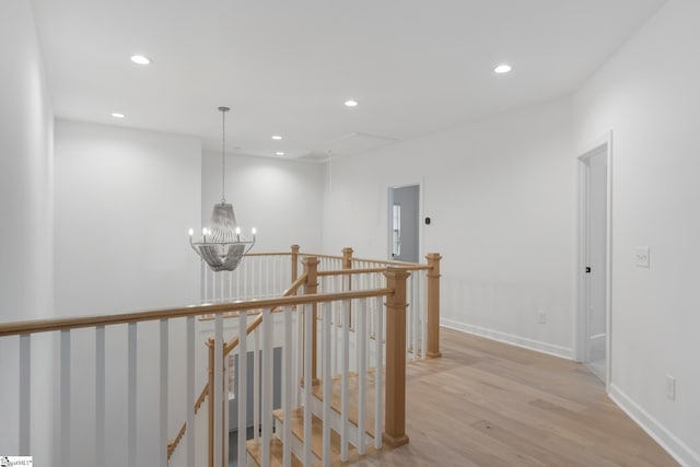 corridor featuring light wood-type flooring, an upstairs landing, and recessed lighting
