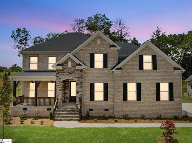 view of front of house with a porch, a front yard, crawl space, and brick siding