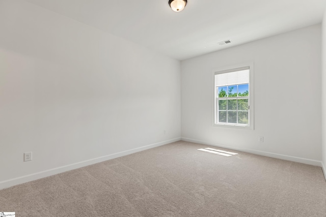 carpeted spare room with baseboards and visible vents