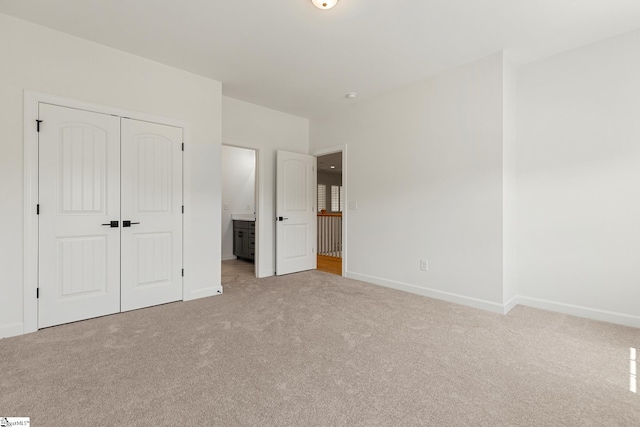 unfurnished bedroom with a closet, carpet flooring, and baseboards