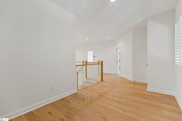 hallway with recessed lighting, an upstairs landing, baseboards, and light wood finished floors