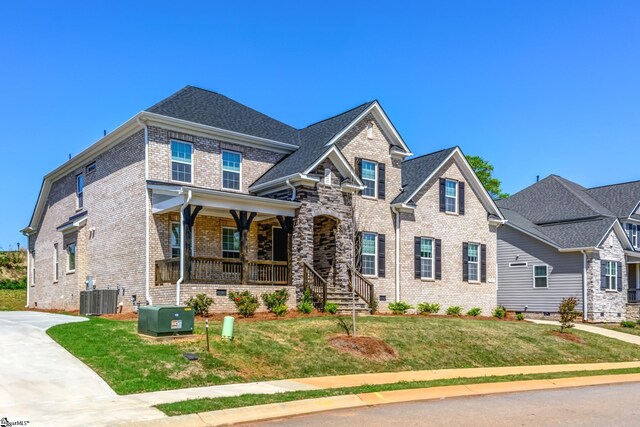 craftsman house featuring crawl space, a porch, a front lawn, brick siding, and central AC unit