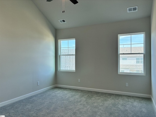 carpeted empty room with visible vents, baseboards, a ceiling fan, and vaulted ceiling