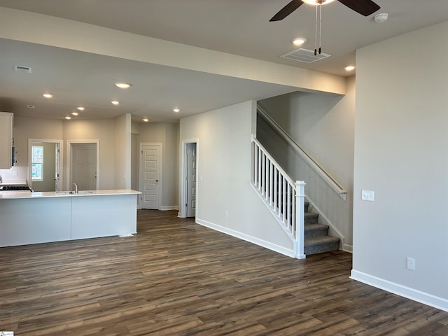 unfurnished living room featuring ceiling fan, visible vents, recessed lighting, stairway, and dark wood-style flooring