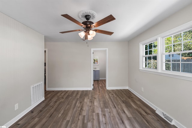 unfurnished room with visible vents, baseboards, and wood finished floors
