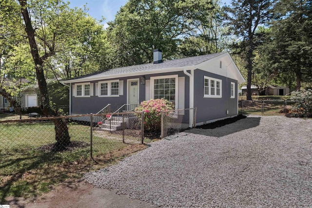view of front of home with a chimney, roof with shingles, and a fenced front yard