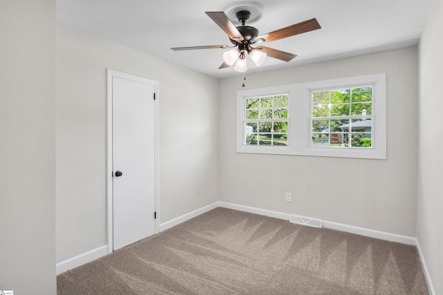 carpeted empty room featuring baseboards, a ceiling fan, and visible vents