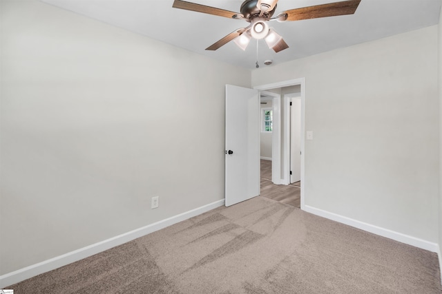 carpeted empty room with ceiling fan and baseboards