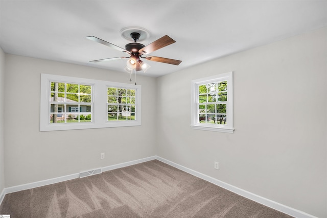 spare room featuring baseboards, a ceiling fan, and plenty of natural light