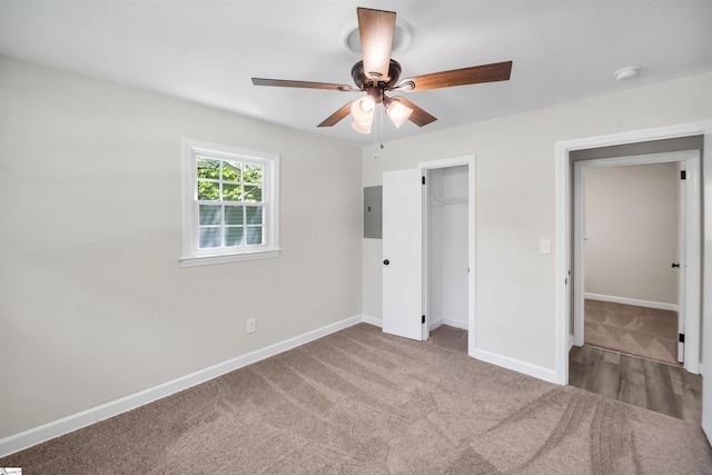 unfurnished bedroom with a closet, baseboards, carpet, and electric panel