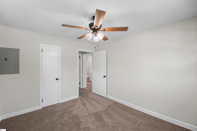 unfurnished bedroom featuring electric panel, carpet flooring, baseboards, and ceiling fan