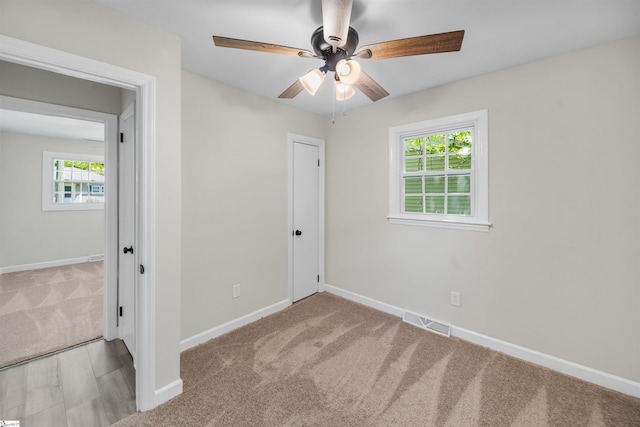 unfurnished bedroom with carpet flooring, visible vents, baseboards, and a ceiling fan