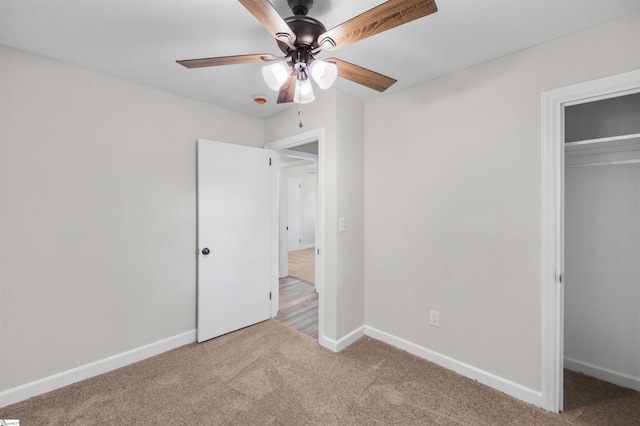 unfurnished bedroom with a closet, baseboards, a ceiling fan, and carpet flooring