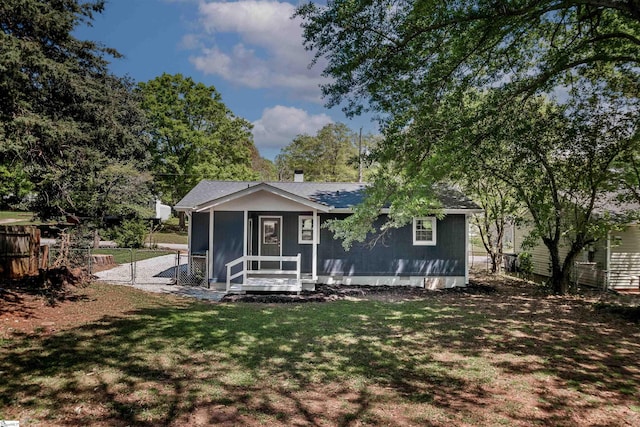 bungalow-style home with a front yard, a sunroom, fence, and a gate