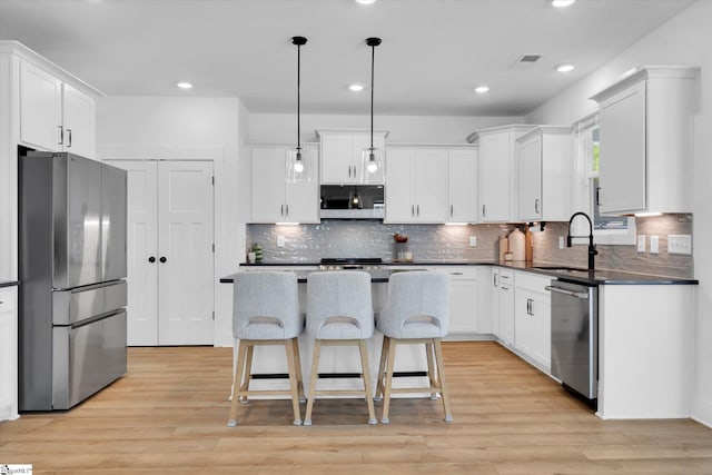102 Moorish Cir, Simpsonville, SC 29681 - kitchen with tasteful backsplash, dark countertops, a kitchen bar, stainless steel appliances, and a sink