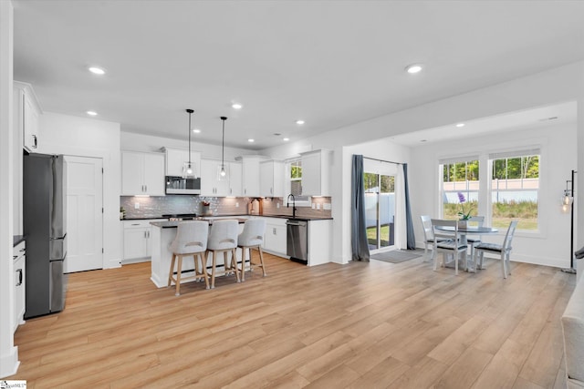 102 Moorish Cir, Simpsonville, SC 29681 - kitchen with a wealth of natural light, dark countertops, a breakfast bar, and appliances with stainless steel finishes