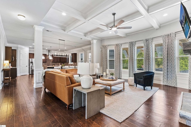 living area featuring a ceiling fan, beamed ceiling, coffered ceiling, dark wood-style floors, and ornate columns